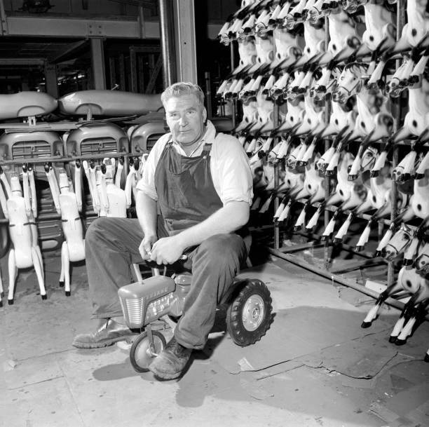 Man sitting on toy tractor Tri-ang factory Merton South London 1965 Old Photo 3