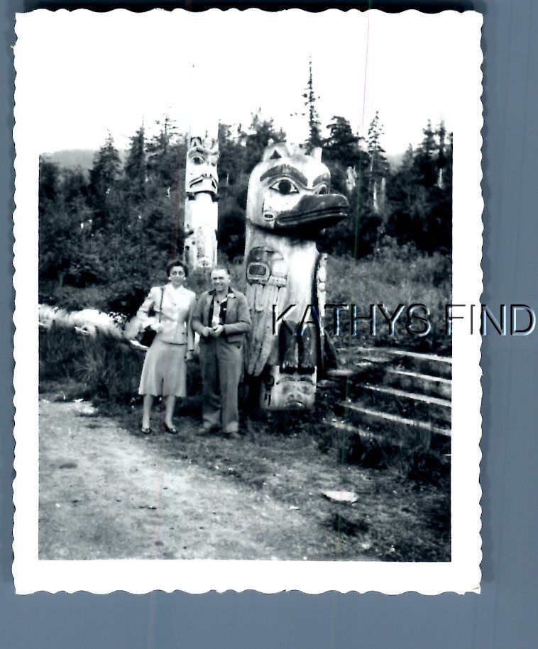 BLACK & WHITE PHOTO U_3219 MAN AND WOMAN POSED BY TOTEM POLES