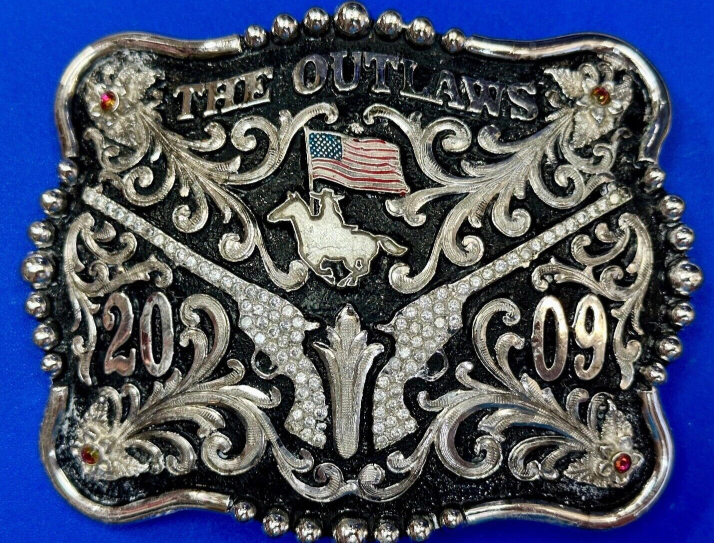 The Outlaws Rodeo Cowboy Trophy 2009 Flag Belt Buckle - Crossroads bucklesTexas