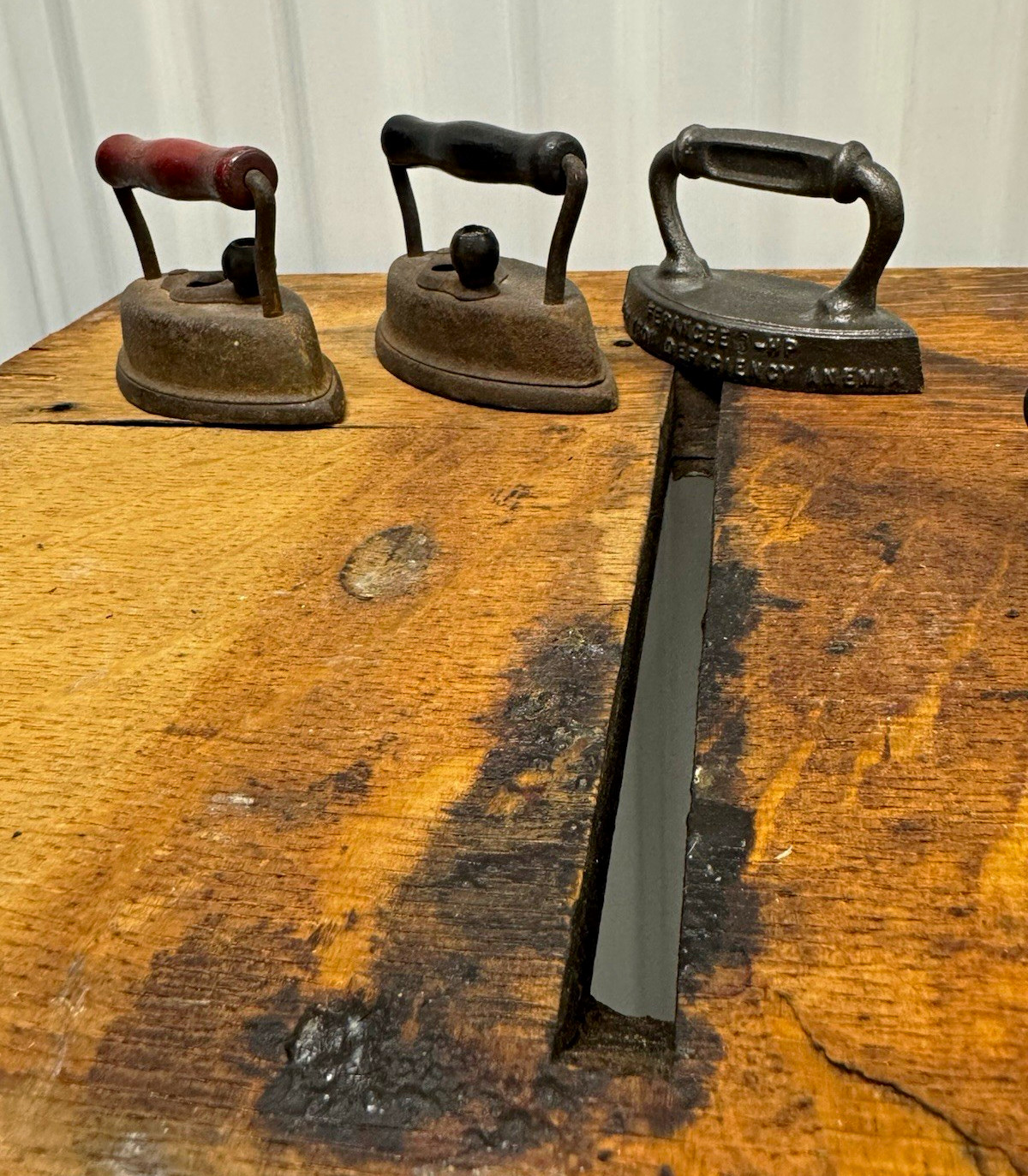 3 antique cast iron irons. And one cast iron trivet 3 antique cast iron irons. And one cast iron trivet