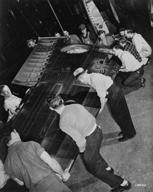 High angle view a group men supporting wing aircraft manufacture a- Old Photo High angle view a group men supporting wing aircraft manufacture a- Old Photo