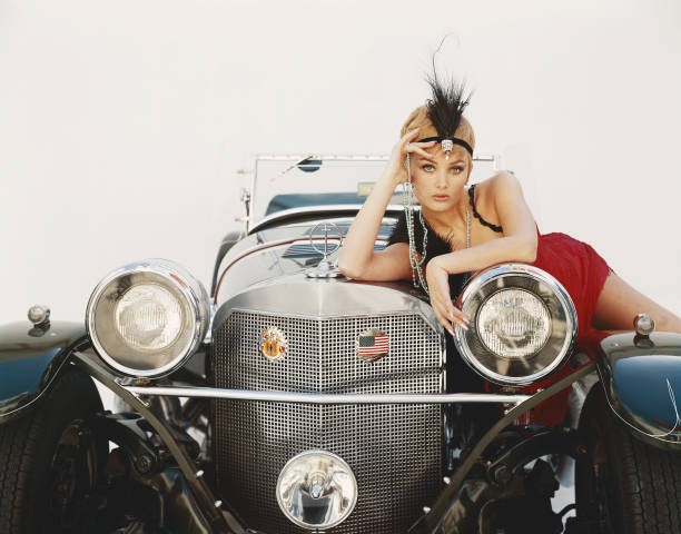 Young woman lying on vintage car portrait Historic 1960s Old Photo Young woman lying on vintage car portrait Historic 1960s Old Photo