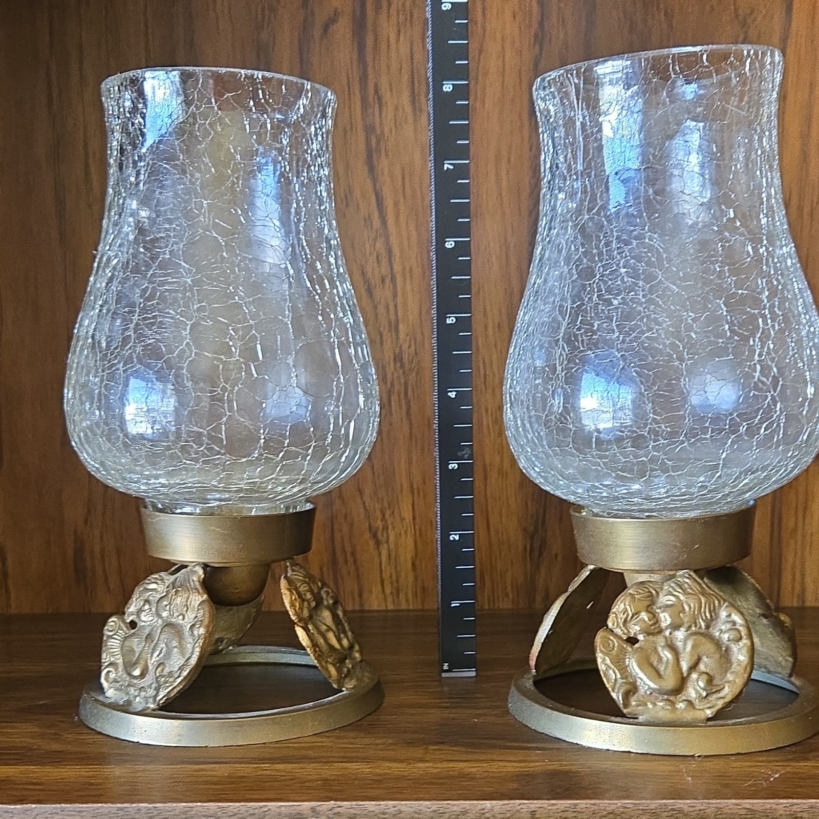 A pair of brass cherub and crackle glass hurricane candle holders by India House A pair of brass cherub and crackle glass hurricane candle holders by India House
