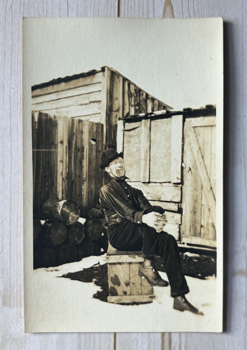Antique RPPC Man Sitting On Crate Outside In Snow