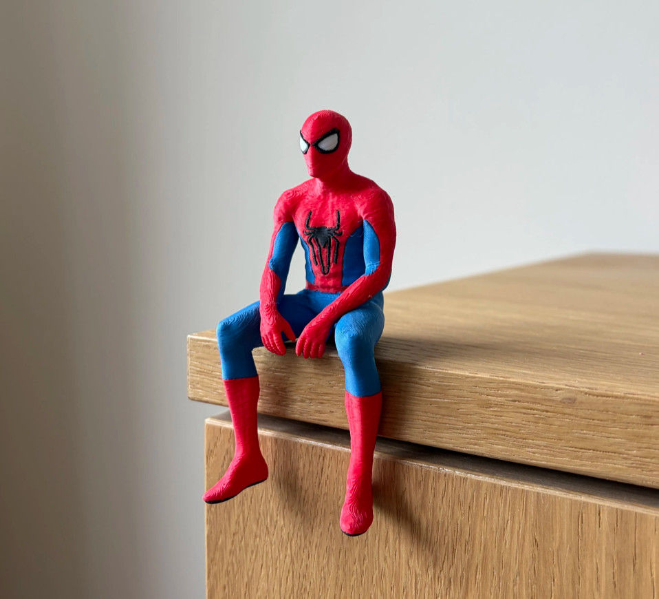 Spiderman Seated Cloak Statue Figurine, sitting on a shelf Spiderman Seated Cloak Statue Figurine, sitting on a shelf