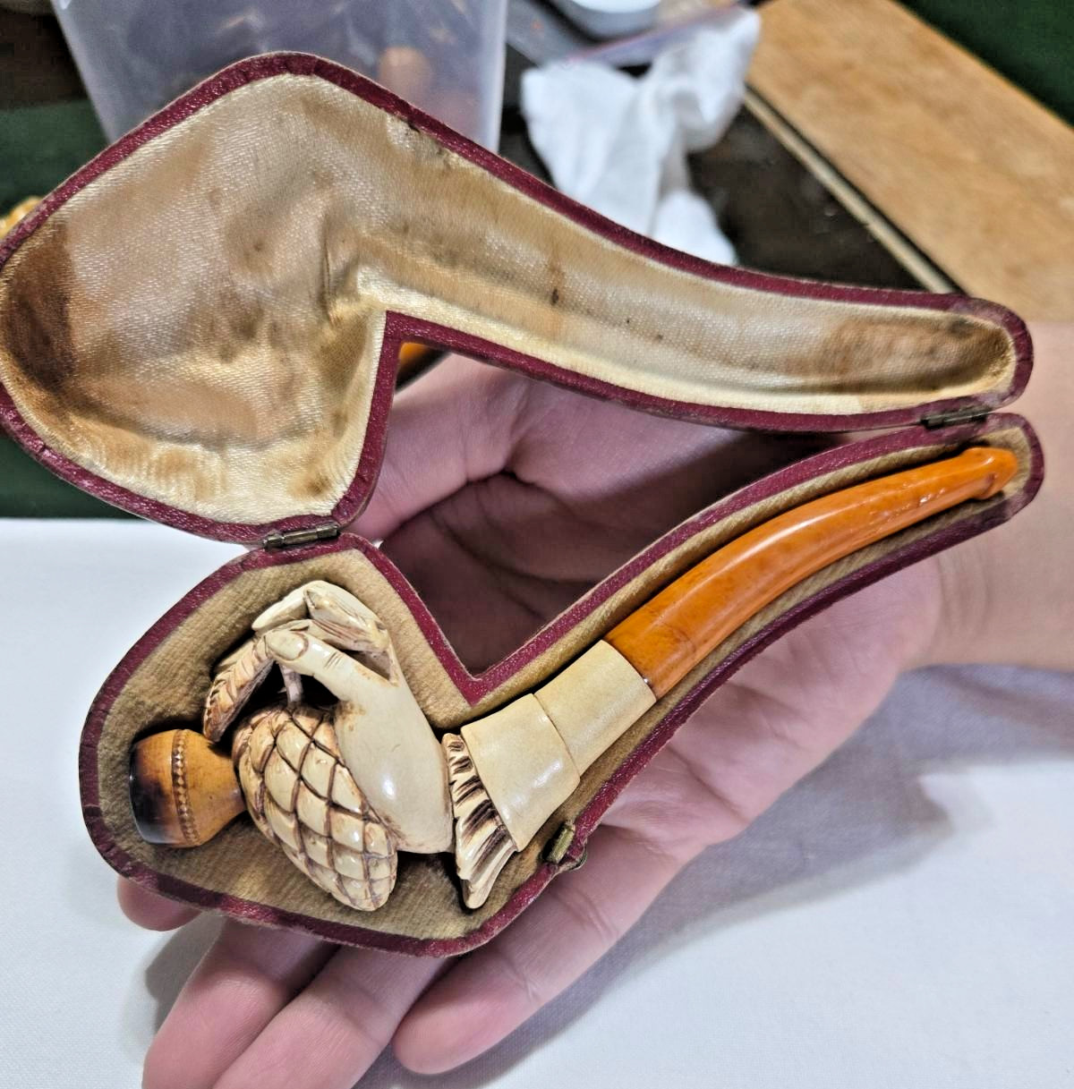 antique carved meerschaum pipe featuring a detailed hand holding a pinecone