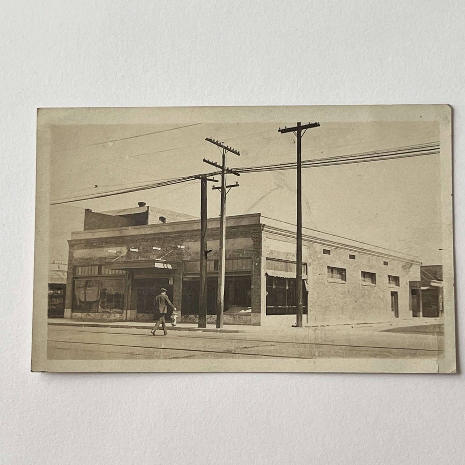 Antique RPPC Real Photograph Postcard Building Man Walking Across Street Poles Antique RPPC Real Photograph Postcard Building Man Walking Across Street Poles