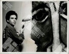 Jean-Michel Basquiat painting a large eye on a wall picture