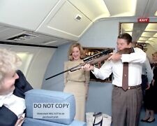 PRESIDENT RONALD REAGAN AIMING A RIFLE ABOARD AIR FORCE ONE - 8X10 PHOTO (RT784) picture