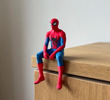 Spiderman Seated Cloak Statue Figurine, sitting on a shelf picture