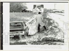 1973 Press Photo An FBI agent waits outside his car at Wegscheid farm in Wadena picture