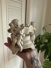 Vintage gold-toned resin candle holder featuring three cherub musicians picture