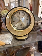 This is a vintage Kruger brand desk or mantel clock. It has a round, gold-tone picture