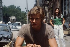 John Schneider on the street with a young lady laughing in the bac- Old Photo picture